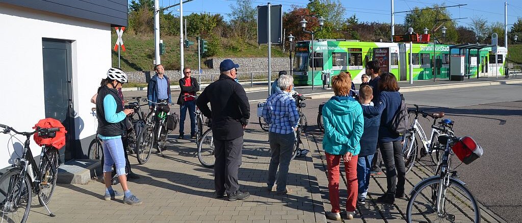 Endhaltestelle der Straßenbahn, Gruppe Radfahrer wartet am Elektro-Haus