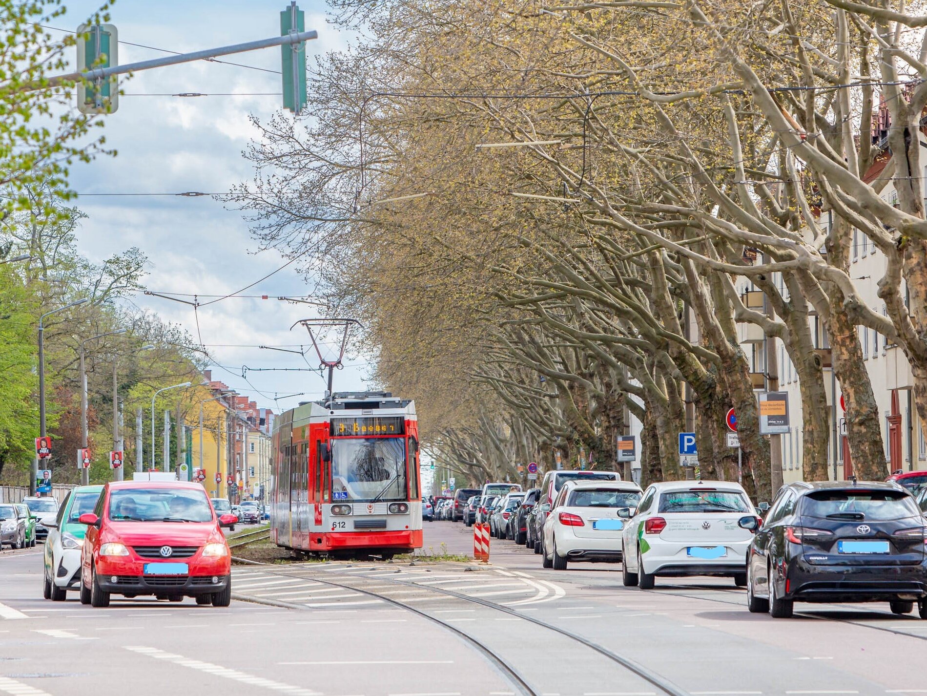 Pkw- und Straßenbahnverkehr entlang der Beesener Straße mit Baumallee an den Straßenrändern